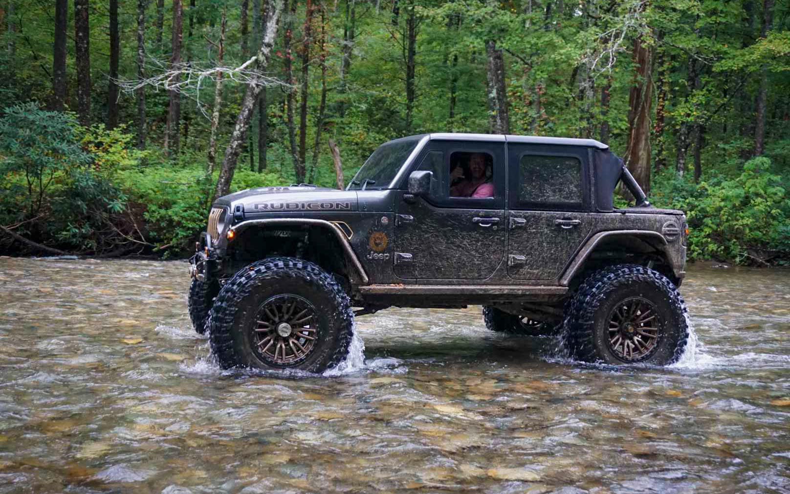 Jeep driving through stream river
